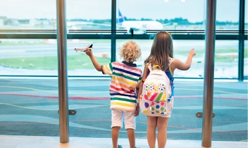 Children at airport watching airplane